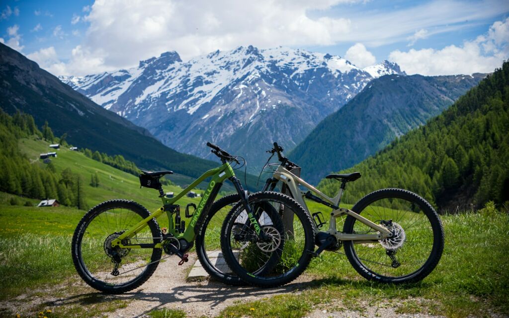 Two electric mountain bikes on a trail in the mountains
