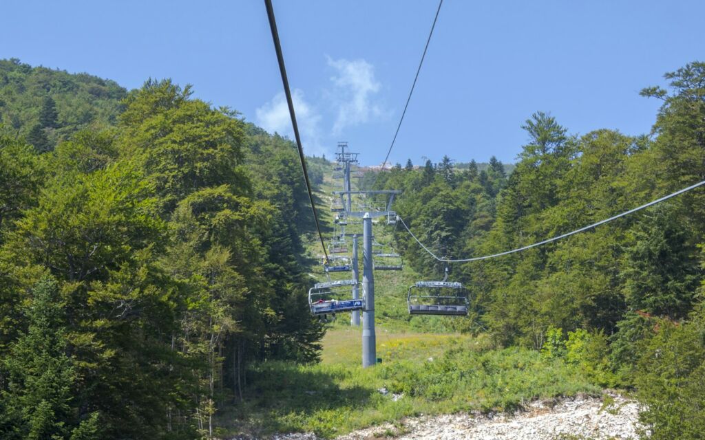 Ski lift running over a green mountain slope in summer